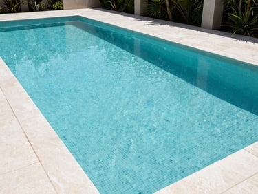 Wide architectural shot of the completed zero-edge pool, pristine turquoise water, flawless Italian mosaic tiling, integrated with modern landscaping.