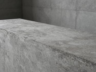 Minimalist industrial interior featuring a raw concrete texture solid surface countertop, cool moody lighting, clean lines