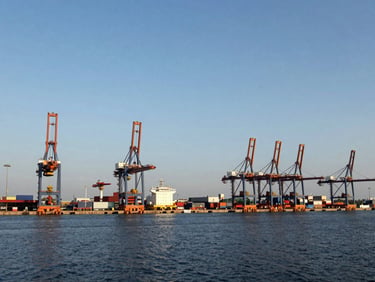Wide environmental perspective of a modern deep-water port and logistics infrastructure under clear daylight, 35mm lens.