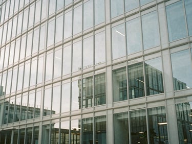 Abstract architectural lines of a glass and steel building, reflecting a secure digital interface, bright neutral daylight, cool desaturated tones, sharp focus, 35mm