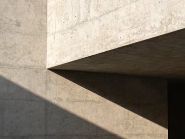 Minimalist architectural concrete structure with strong geometric shadows, warm natural side lighting, clean lines.