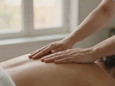 Close-up of professional female hands performing a precise massage technique on a client's shoulder, soft window daylight, focus on hands and gentle movement.