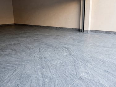 Architectural interior photography of a modern garage floor with seamless slate gray resin coating, clean geometric lines, soft daylight