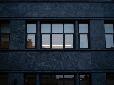 Sober architectural detail of a modern courthouse facade, soft window light, minimalist composition, deep navy tones