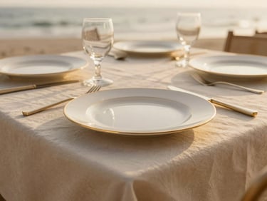 Detailed shot of gold-rimmed tableware on beige linens, soft natural coastal light, 35mm editorial