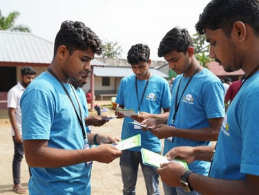 Documentary photo of young adult volunteers distributing educational pamphlets at an outdoor community center in Guntur, bright daylight