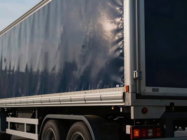 Close-up of a modern clean cargo truck trailer, metallic textures, dramatic daylight, 35mm