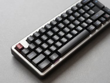 Close-up overhead studio shot of a mechanical gaming keyboard on a neutral gray surface, even shadowless lighting, showing key legends and aluminum frame detail clearly, no RGB glow