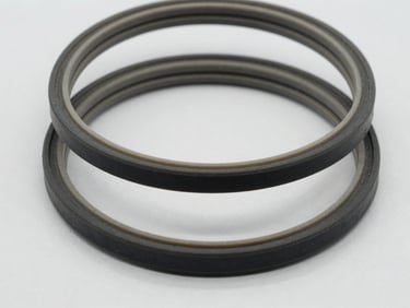 Close-up macro shot of industrial rubber gaskets showing clean edges, neatly stacked on a neutral light gray background, bright high-key studio lighting, 50mm lens