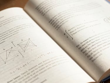 Macro shot of an open, beautifully typeset mathematics textbook showing clean editorial layouts and precise geometric diagrams, bright natural daylight