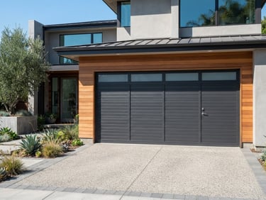 Crisp architectural photography of a modern charcoal-grey aluminum garage door installed on a contemporary California home, bright natural daylight, sharp focus, 35mm lens