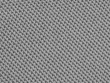 Macro flat-overhead close-up of polyester-spandex performance knit fabric under cool studio strobe, tight weave structure visible, neutral light grey surface, no garments