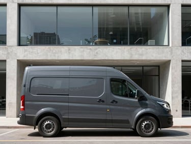 A clean, branded dark grey cargo van parked outside a minimalist modern concrete office building, bright daylight, sharp architectural lines.