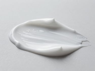 Macro shot of a cosmetic cream texture being gently spread, highlighting its smooth and even consistency, clean neutral studio lighting, cool desaturated tones, sharp focus, shallow depth of field, clinical aesthetic