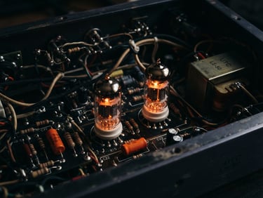 Macro photograph of glowing vacuum tubes inside a high-end analog compressor, warm amber light, deep shadows, cinematic studio lighting, 50mm lens