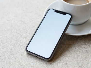 A smartphone displaying a clean, minimalist interface resting next to a coffee cup on a stone surface, bright daylight, 35mm