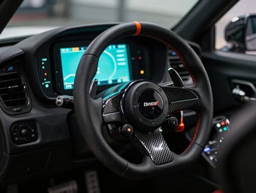 Close-up of a professional racing simulator with direct-drive steering wheel, carbon paddle shifters, telemetry screen glowing cyan, dark moody lighting