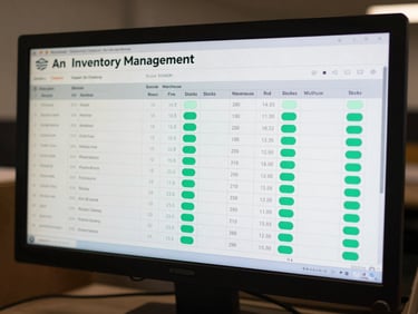 An inventory management dashboard on a desktop monitor, showcasing multi-warehouse stocks, tabular layout, and active mint-green indicators