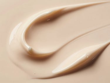 Close up of luxury cream foundation texture, elegant swirls in warm cream and champagne tones, soft studio light