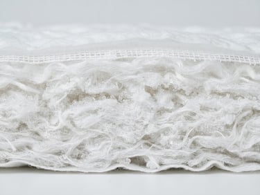 Macro studio shot of unbranded white diaper core layers, showing clinical fiber textures, bright high-key lighting, soft neutral background.