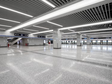 Completed Shenzhen Metro station concourse interior, finished terrazzo floor and overhead soffit with integrated lighting, station signage installed, overcast daylight from entrance shafts, no passengers, facility ready for service