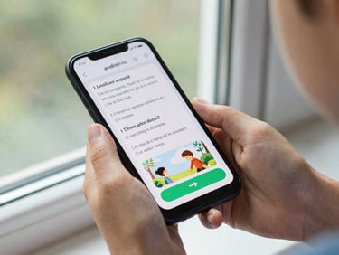Child's hand holding a small Android phone near a window, screen showing a storybook reading app with large illustrated text and a single large next-page button, natural light, tight device crop