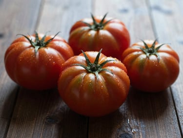 Raw organic heirloom tomatoes on a dark wooden surface, soft diffused overcast light, rich deep tones, 35mm lens