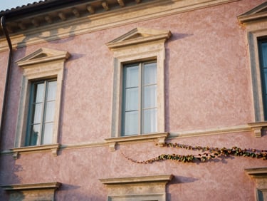 Close-up architectural detail of a historic Italian villa facade, soft terracotta walls, ivy, warm morning light, shallow depth of field, 35mm film.