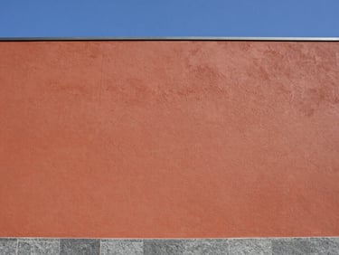 Wide-angle shot of a clean, freshly washed building facade against a blue sky, bright natural daylight, high-contrast textures.