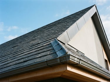 Low-angle architectural shot of a modern slate roof with precise zinc flashing under crisp daylight, sharp focus, 35mm