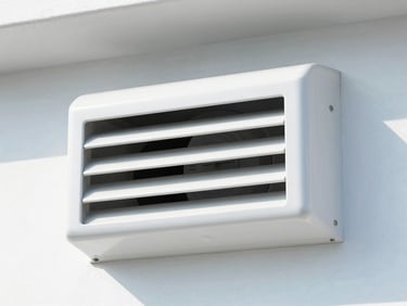 Close-up of clean dryer exhaust vent hood on an exterior wall, bright daylight, sharp focus