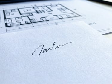 Close-up of a signed technical document on a clean desk, architectural plans in the background