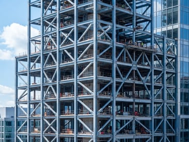 Crisp architectural photography of a modern building steel frame under bright daylight, cool blue tones, sharp focus, 35mm lens