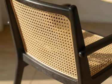 Detail of intricate geometric cane weaving on a modern minimalist chair frame, soft natural light, warm shadows