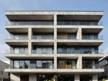 Wide architectural photograph of a modern residential building in Bogotá under bright natural daylight, clean sharp focus, showing structural details and concrete textures, 35mm lens.
