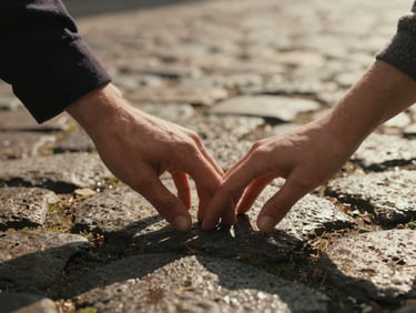 Intimate close-up of a couple's hands gently touching on a wet cobblestone street, soft late-afternoon shadows, rich textures of wool and stone, warm vintage tones.