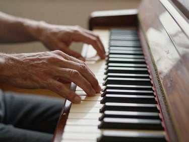 Intimate close-up of hands on polished piano keys, soft morning light streaming from a side window, warm wood textures.