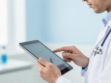 Close-up of a male healthcare professional reviewing clinical data on a modern tablet, bright clinical lighting, blue and white tones