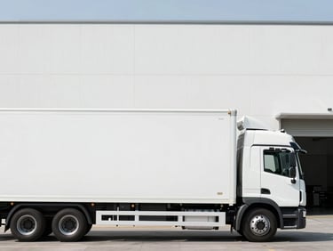 Minimalist side view of a white modern logistics truck parked near a clean architectural warehouse, daylight