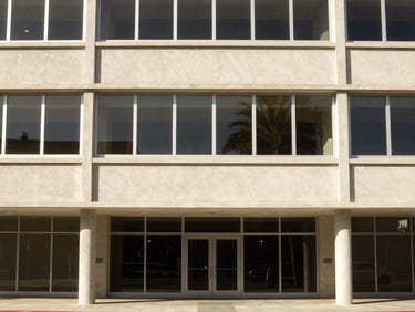 Mid-century modern commercial office building in Southern California, clean architectural lines, bright natural daylight, warm tones.