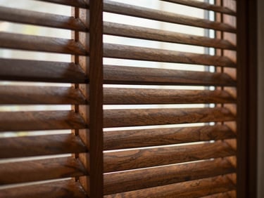 Close-up of elegant wooden louvers, soft side-lit window glow, rich wood grain, deep shadows, warm editorial interior photography, shallow depth of field, 35mm
