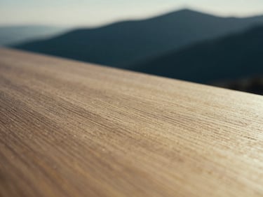 Close-up of fine, textured material (e.g., polished wood grain or natural stone) with soft, low-contrast daylight, muted navy and gold tones, shallow depth of field, 35mm.