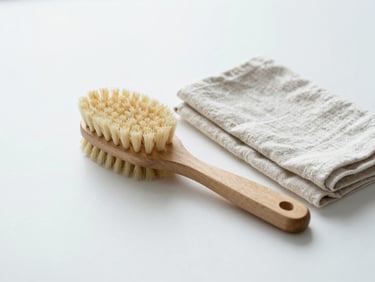 A minimalist wooden scrubbing brush next to a folded linen cloth on a clean surface, bright daylight, desaturated cool tones.