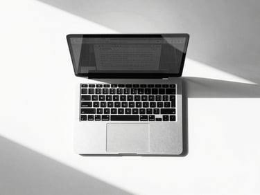 Straight-on flat lay of a minimalist monochrome workspace, a sleek modern laptop displaying a clean structured browser layout, sharp geometric shadows on a bright white desk, high-contrast studio light, stark black and white tones, 50mm lens