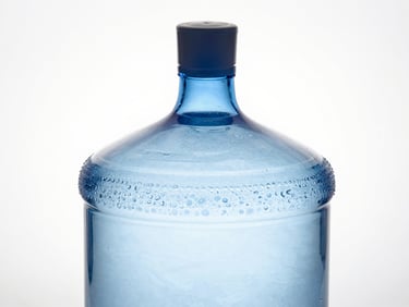 Macro studio photograph of a massive, perfectly spherical 20-litre glass water jar, glowing with subtle internal blue light, sharp metallic cap, clinical white background