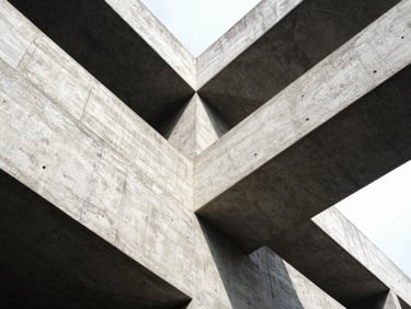 Low-angle heroic shot of complex concrete angles meeting, high-contrast daylight, 35mm