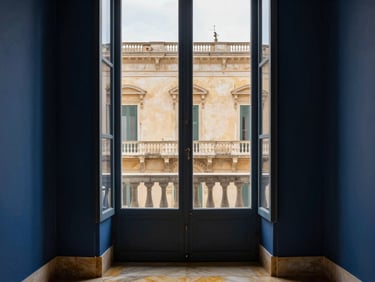 luxury editorial interior photography, soft natural window light, deep midnight blue and warm gold tones, 35mm architectural lens, historic Italian palazzo facade in Foggia