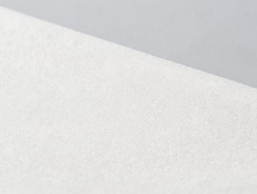 Close-up of premium organic cotton canvas fabric texture, clean weave, sharp focus, bright studio lighting, neutral gray backdrop
