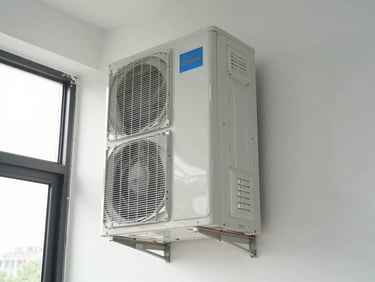 Ductless mini-split indoor air handler mounted high on a wall in a commercial office space, natural daylight from windows, clean wall surface, copper line-set running neatly to exterior