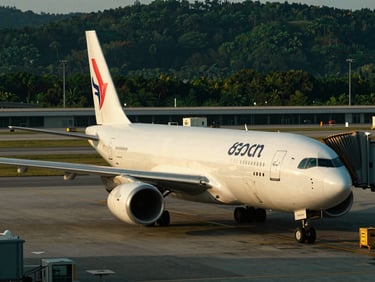 Cargo plane being loaded at a modern international airport terminal at dusk, deep forest green tones, sharp focus, 35mm